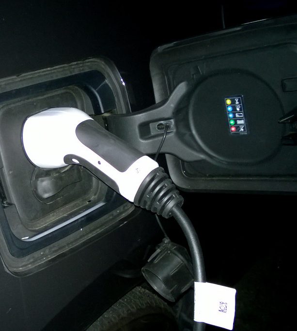 Electric vehicle charging connector plugged into a car