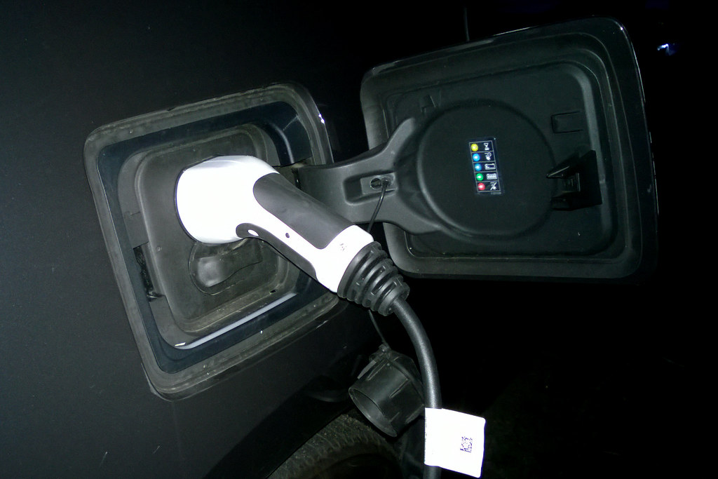 Electric vehicle charging connector plugged into a car