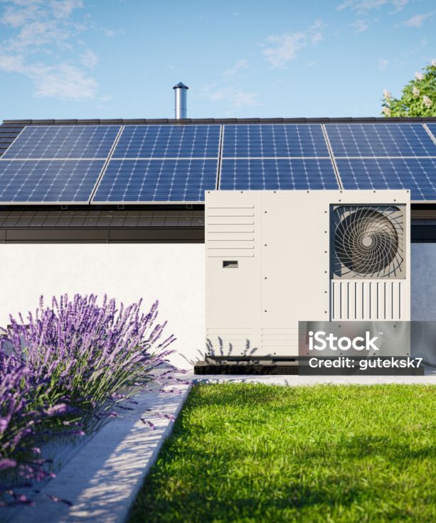 A heat pump with photovoltaic panels installed on the roof of a single-family house, along with a green roof covered in grass over the garage, forms an eco-friendly heating and air conditioning solution for the property